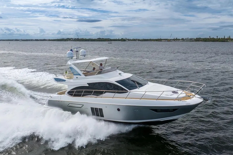 Slide: The Image of 2014 Azimut 54 Flybridge yacht cruising on open water under a cloudy sky. - 7