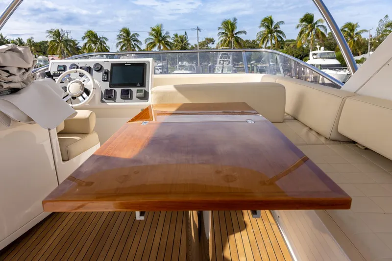 Slide: The Image of 2014 Azimut 54 Flybridge yacht interior with polished wood table and modern helm controls. - 73