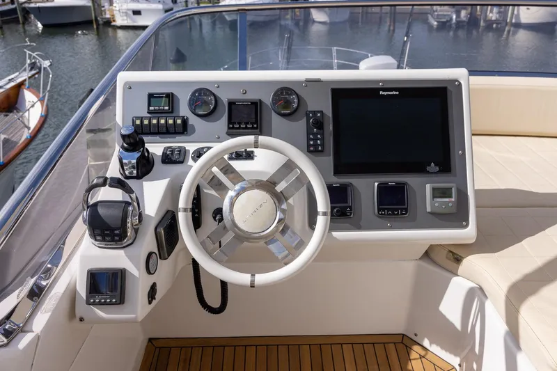 Slide: The Image of 2014 Azimut 54 Flybridge yacht helm with modern navigation controls and steering wheel. - 74