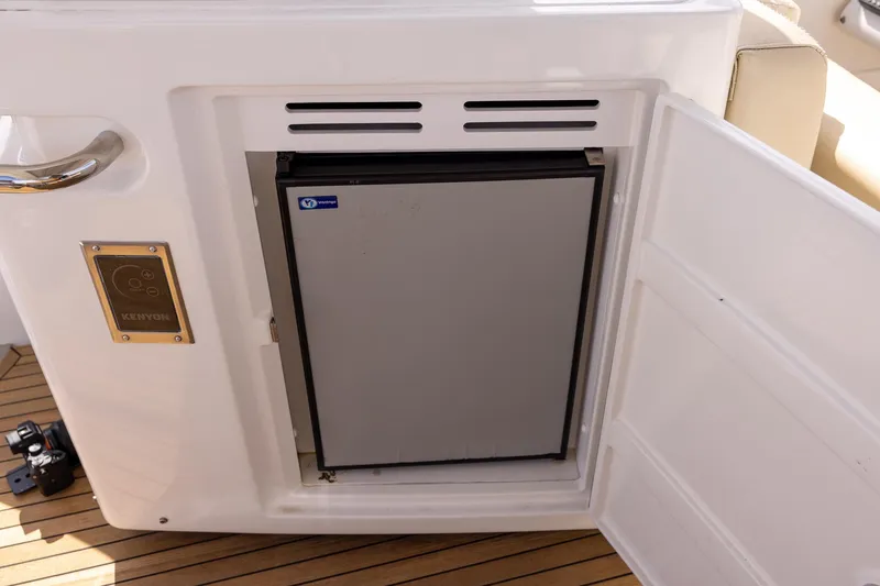 Slide: The Image of Built-in fridge on 2014 Azimut 54 Flybridge yacht, open door, teak deck visible. - 79