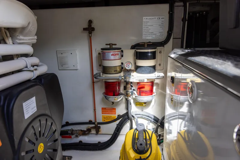 Slide: The Image of Engine room of 2014 Azimut 54 Flybridge yacht, showcasing fuel filters and machinery. - 89