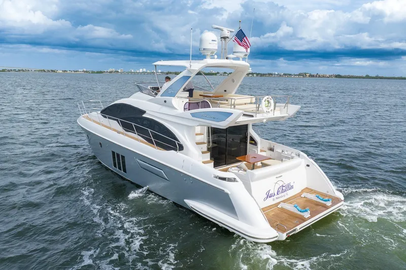 Slide: The Image of 2014 Azimut 54 Flybridge yacht cruising on open water under cloudy skies. - 9