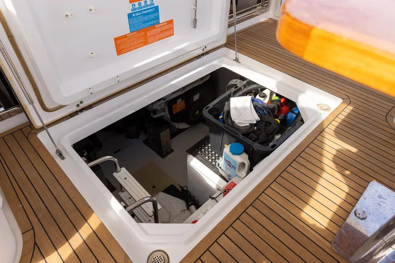 Slide: The Image of Open hatch on 2014 Azimut 54 Flybridge yacht, revealing storage compartment with various items. - 90