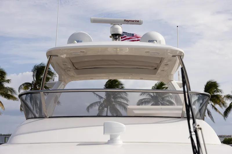 Slide: The Image of 2014 Azimut 54 Flybridge yacht with radar, palm trees, and American flag. - 93