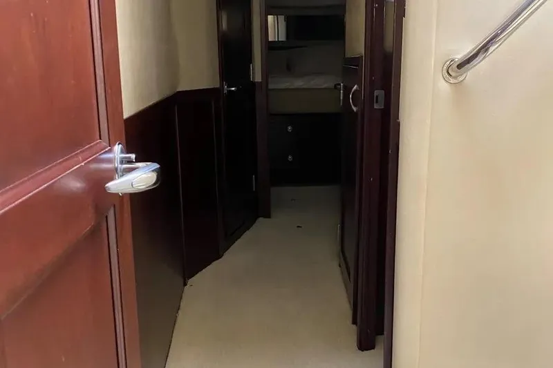 Slide: The Image of Interior hallway of 2006 Sea Ray 580 Sedan Bridge yacht, featuring wooden doors and beige walls. - 10