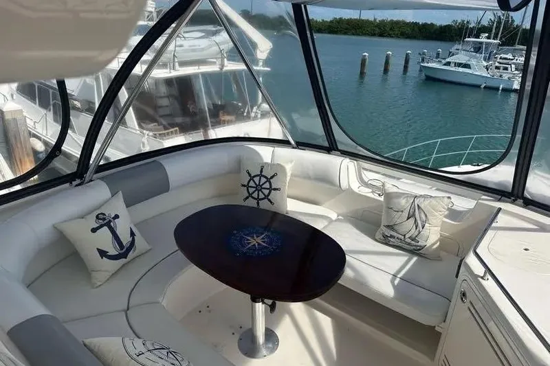Slide: The Image of Luxurious 2006 Sea Ray 580 Sedan Bridge interior with nautical-themed cushions and waterfront view. - 35