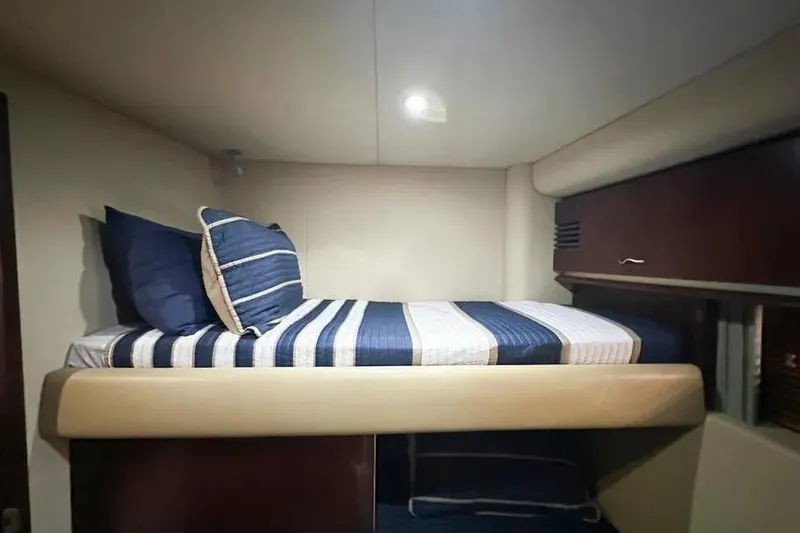 Slide: The Image of 2006 Sea Ray 580 Sedan Bridge cabin with striped bedding and cozy lighting. - 37