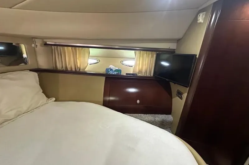 Slide: The Image of Interior cabin of 2006 Sea Ray 580 Sedan Bridge with bed, TV, and porthole windows. - 57