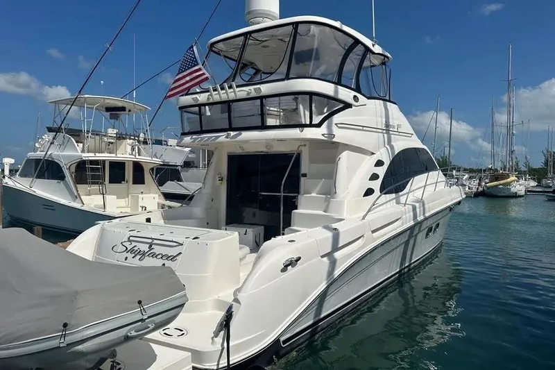 Slide: The Image of 2006 Sea Ray 580 Sedan Bridge yacht docked in a marina under a clear blue sky. - 63