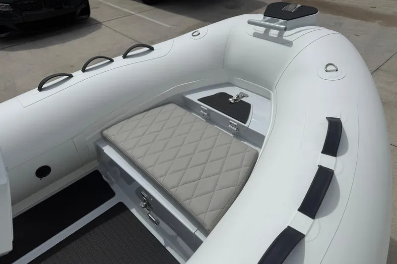 Slide: The Image of 2026 East Marine 320 inflatable boat with cushioned seating and storage compartment. - 11