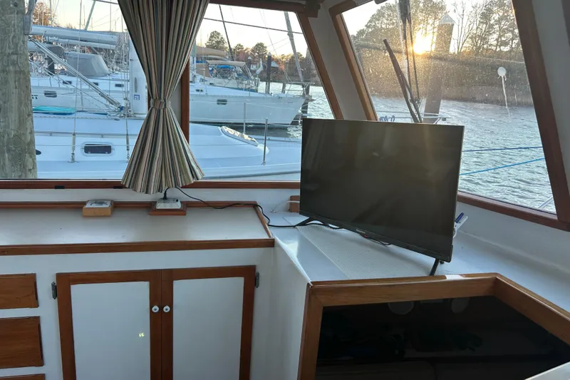 Slide: The Image of Interior of a 1991 Holland 38 boat with a TV and marina view. - 13