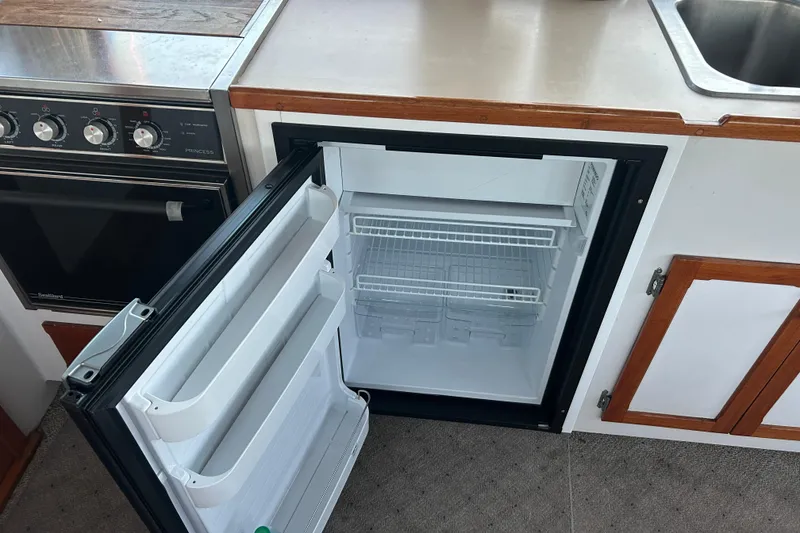 Slide: The Image of Open refrigerator in a 1991 Holland 38 boat kitchen, next to an oven and sink. - 18