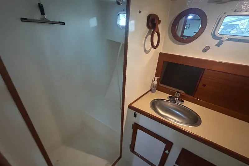 Slide: The Image of Bathroom interior of 1991 Holland 38 boat with sink, mirror, and shower area. - 20