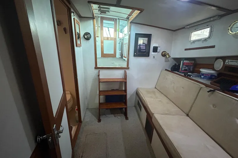 Slide: The Image of Interior of a 1991 Holland 38 boat featuring seating, storage, and nautical decor. - 23