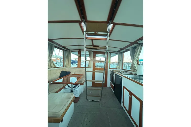Slide: The Image of Interior of 1991 Holland 38 boat with seating, table, and kitchen area. - 26