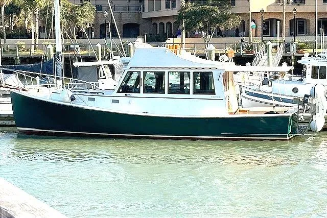 Slide: The Image of 1991 Holland 38 boat docked in a marina, featuring a green hull and white cabin. - 3