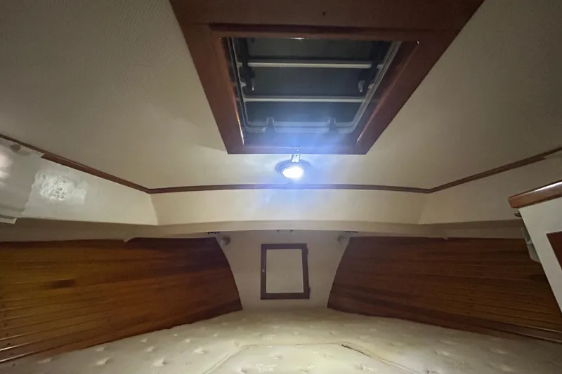 Slide: The Image of Interior cabin of a 1991 Holland 38 boat with wooden paneling and ceiling hatch. - 30