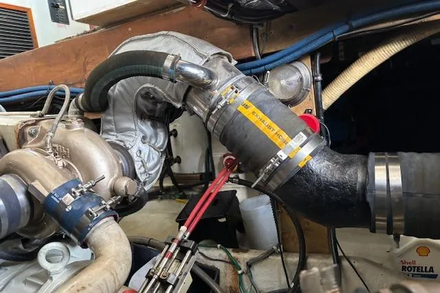 Slide: The Image of Engine components of a 1991 Holland 38, featuring exhaust hoses and turbocharger. - 35