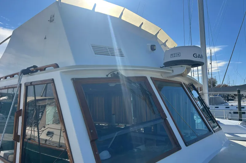 Slide: The Image of 1991 Holland 38 boat with Garmin radar, docked under clear blue sky. - 41