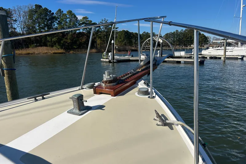 Slide: The Image of Bow of 1991 Holland 38 boat docked in a marina, surrounded by calm water. - 43
