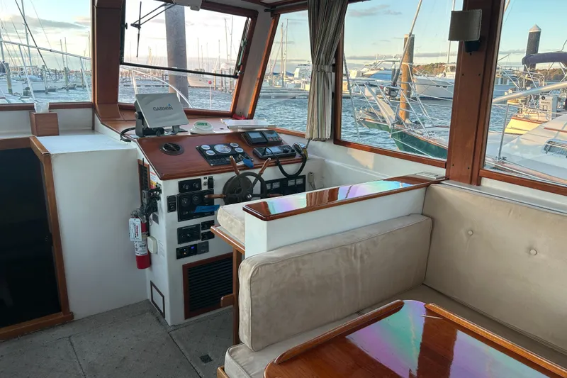 Slide: The Image of Interior of a 1991 Holland 38 boat with helm, seating, and marina view. - 5
