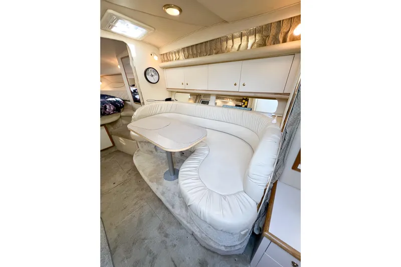 Slide: The Image of Interior of 2000 Sea Ray 340 Sundancer with white leather seating and compact dining area. - 14