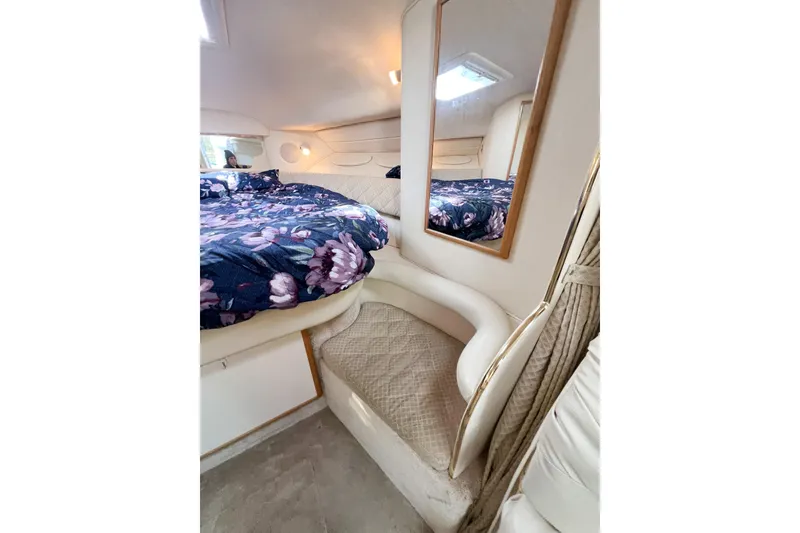 Slide: The Image of Interior of 2000 Sea Ray 340 Sundancer with floral bedding and cozy seating area. - 15