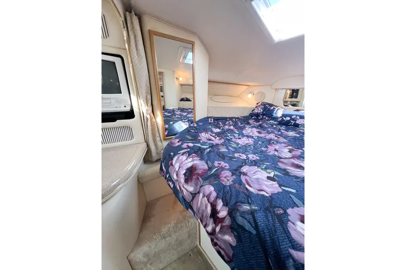 Slide: The Image of Interior of 2000 Sea Ray 340 Sundancer with floral bedding and cozy cabin design. - 16
