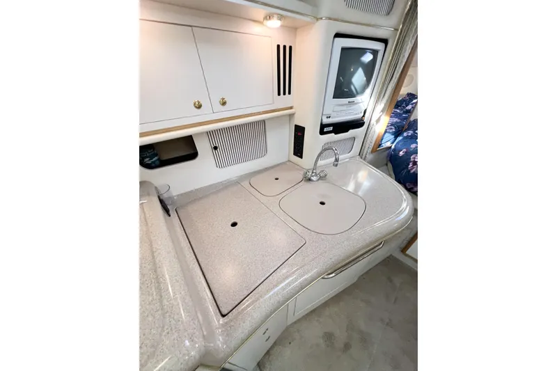 Slide: The Image of 2000 Sea Ray 340 Sundancer interior kitchen with sink, cabinets, and built-in appliances. - 23