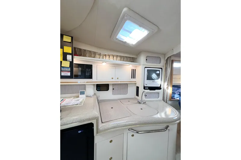 Slide: The Image of Interior of 2000 Sea Ray 340 Sundancer yacht, featuring a compact kitchen area. - 24
