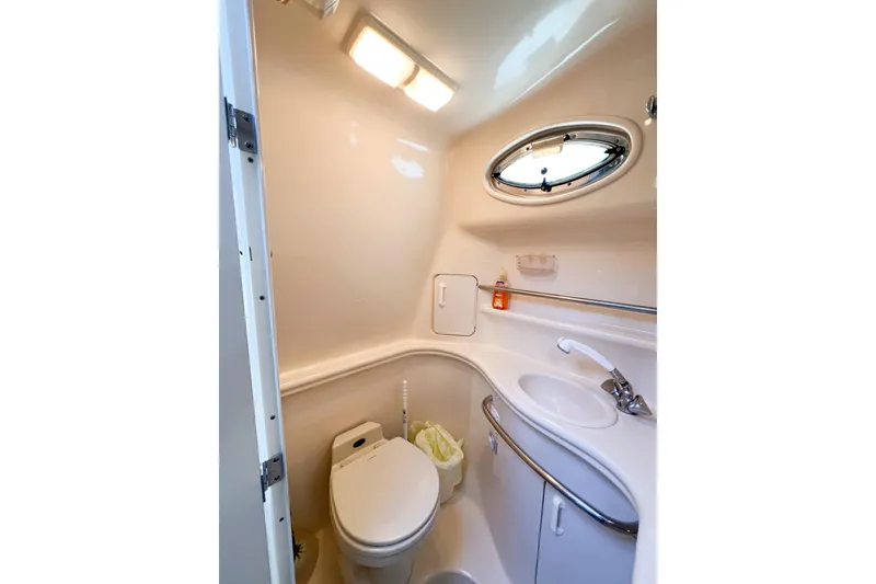 Slide: The Image of Compact bathroom in 2000 Sea Ray 340 Sundancer yacht, featuring toilet and sink. - 29
