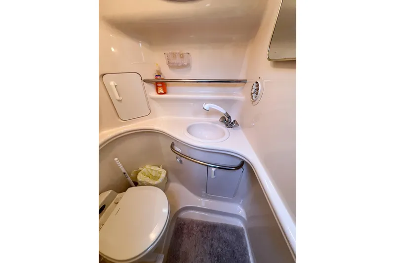 Slide: The Image of Compact bathroom in a 2000 Sea Ray 340 Sundancer boat, featuring sink and toilet. - 30