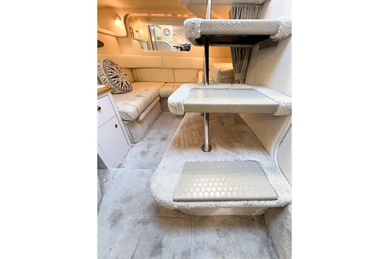 Slide: The Image of Interior of 2000 Sea Ray 340 Sundancer with carpeted stairs and cozy seating area. - 32
