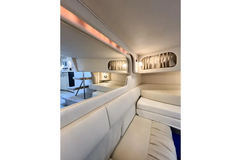 Slide: The Image of Interior of 2000 Sea Ray 340 Sundancer yacht, featuring elegant seating and ambient lighting. - 35