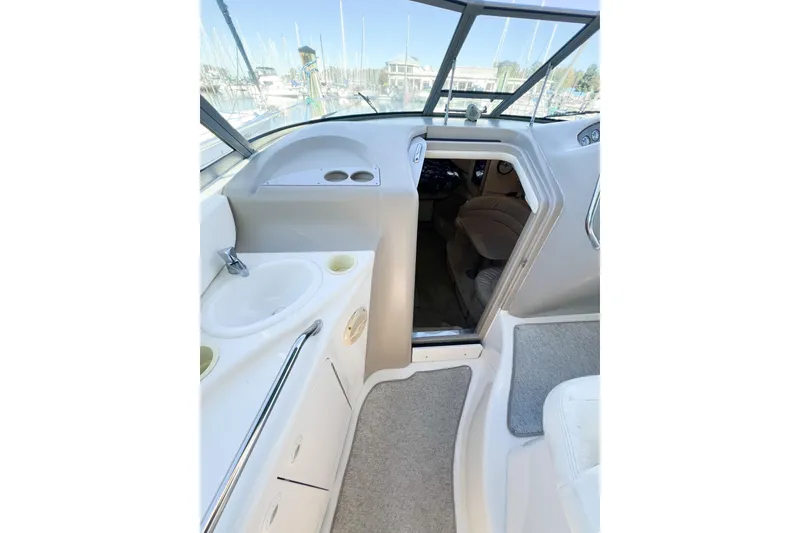 Slide: The Image of Interior view of a 2000 Sea Ray 340 Sundancer boat, featuring a sink and cabin entrance. - 48