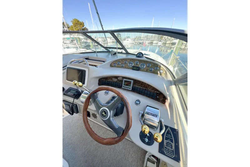 Slide: The Image of Cockpit view of 2000 Sea Ray 340 Sundancer with steering wheel and control panel. - 54