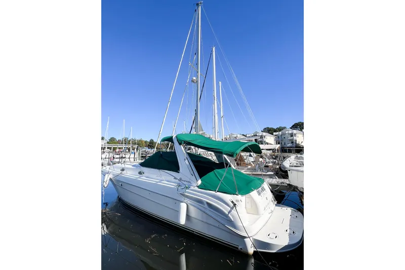 Slide: The Image of 2000 Sea Ray 340 Sundancer boat docked with green canopy under clear blue sky. - 6