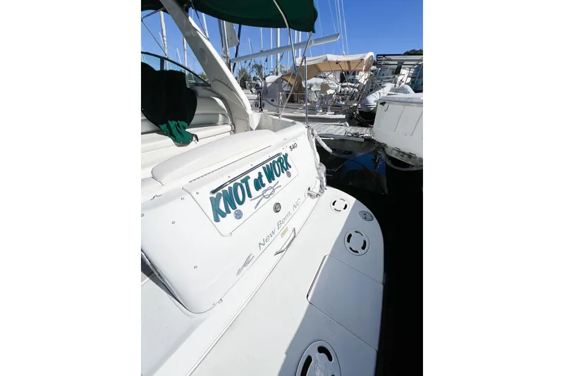 Slide: The Image of Sea Ray 340 Sundancer 2000 boat docked, featuring "Knot at Work" sign. - 7