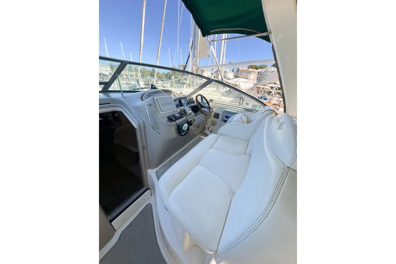 Slide: The Image of Interior view of 2000 Sea Ray 340 Sundancer boat with white seating and control panel. - 8