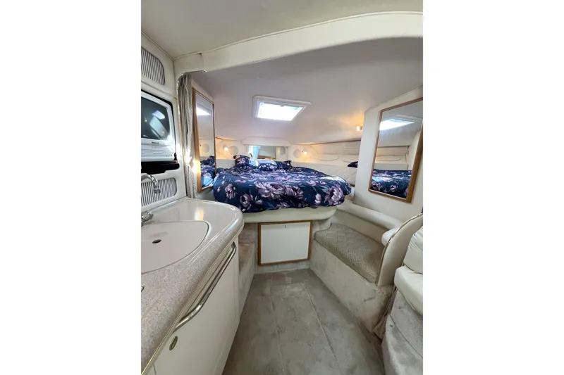 Slide: The Image of Interior cabin of 2000 Sea Ray 340 Sundancer with bed, sink, and mirrors. - 9