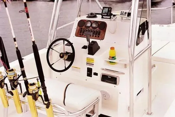 Slide: The Image of 2001 Century 2300 Center Console boat with fishing rods and steering controls. - 13