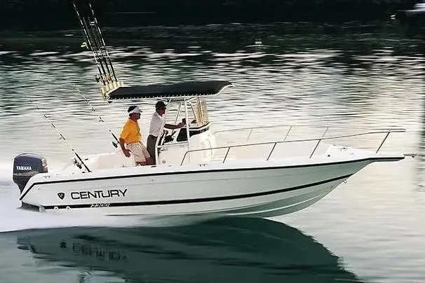 Slide: The Image of 2001 Century 2300 Center Console boat cruising on calm water with two passengers. - 15