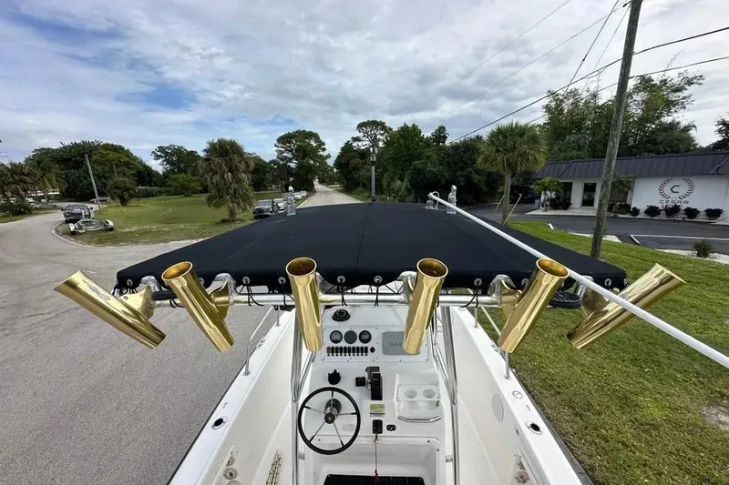 Slide: The Image of 2001 Century 2300 Center Console boat with gold rod holders and black canopy. - 8