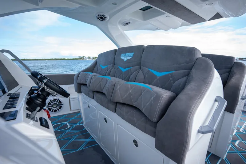 Slide: The Image of 2025 Deep Impact 499 Sport boat interior with plush seating and modern dashboard. - 22