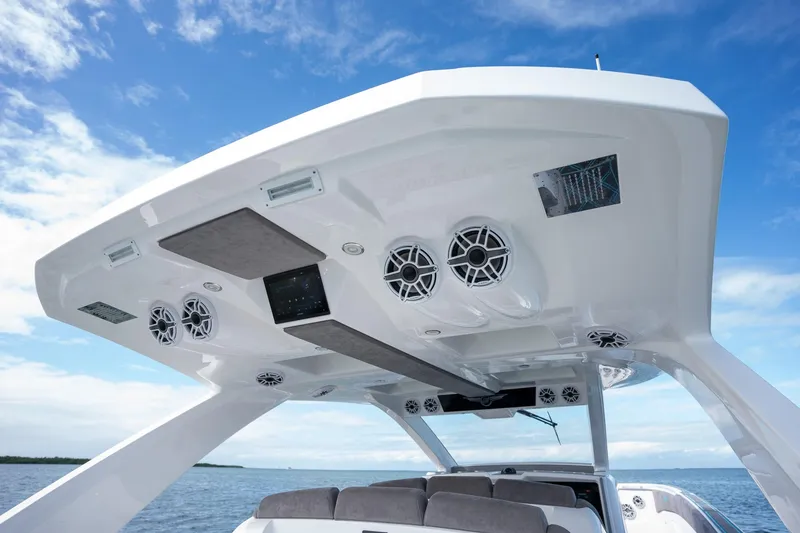 Slide: The Image of 2025 Deep Impact 499 Sport boat with advanced audio system and sleek design under blue sky. - 37