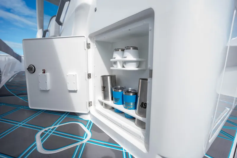 Slide: The Image of Open storage compartment on 2025 Deep Impact 499 Sport boat, holding cups and tumblers. - 42