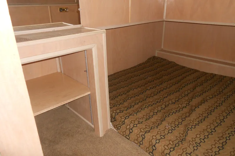 Slide: The Image of Interior of 1993 Stardust Cruisers 5715, featuring a cozy bed and wooden shelving. - 11