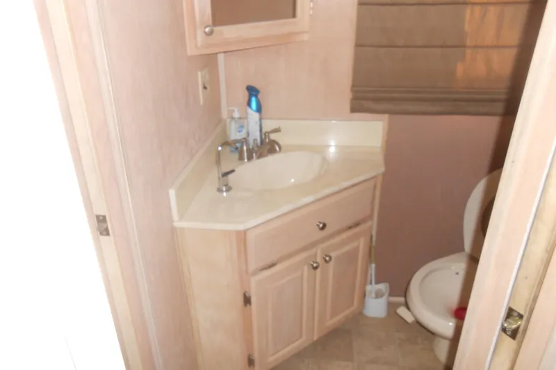 Slide: The Image of Compact bathroom with sink, cabinet, and toilet in a 1993 Stardust Cruisers 5715. - 13