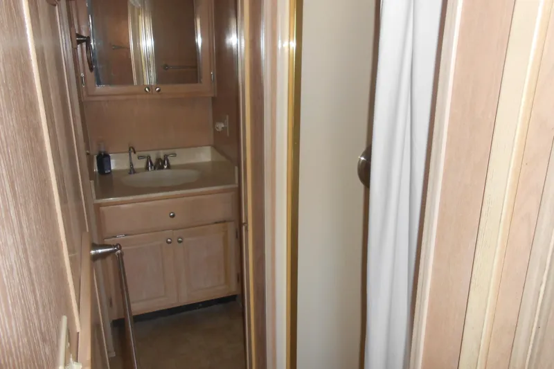 Slide: The Image of Bathroom interior of 1993 Stardust Cruisers 5715 with wooden cabinetry and sink. - 14