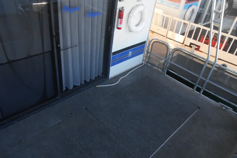 Slide: The Image of 1993 Stardust Cruisers 5715 houseboat deck with safety equipment and sliding door. - 19